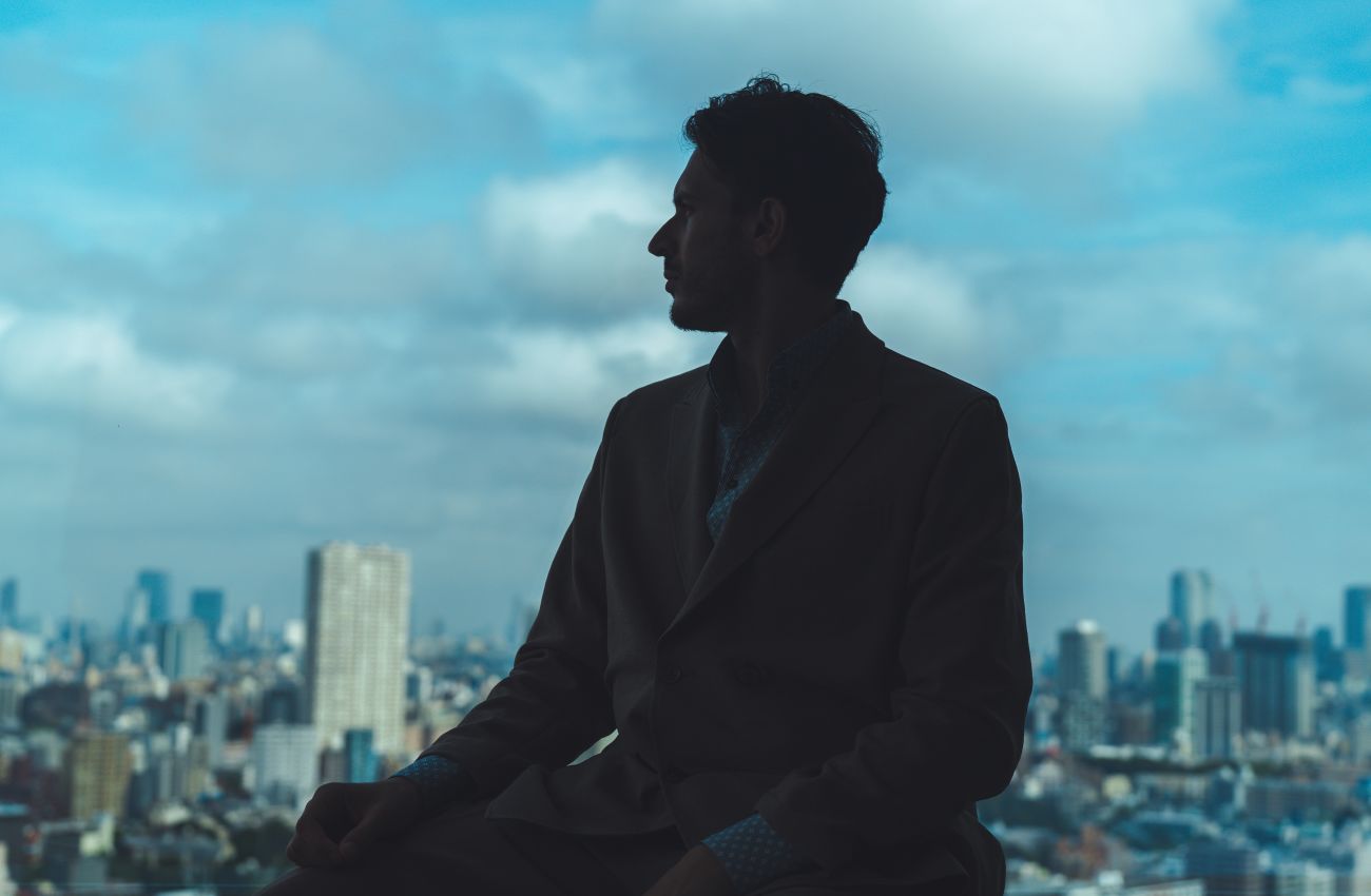 A Man Standing In Front Of A City Skyline