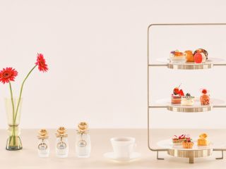 A Table With A Vase Of Flowers And A Glass Shelf With Objects