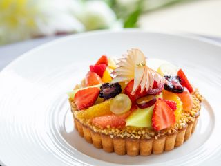 A Piece Of Cake On A White Plate Topped With Fruit