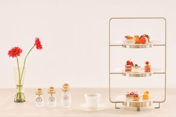 A Table With A Vase Of Flowers And A Glass Shelf With Objects